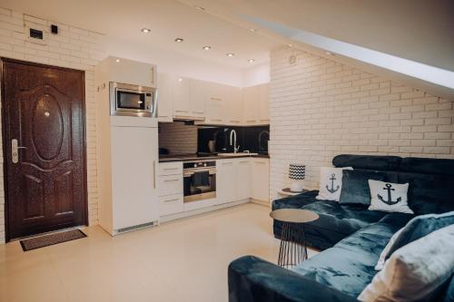 a living room with a couch and a kitchen at Apartament Kotwica in Giżycko