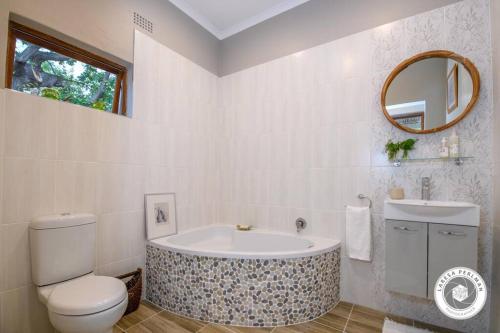 a bathroom with a tub and a toilet and a sink at Wijnberg Cottage in Montagu