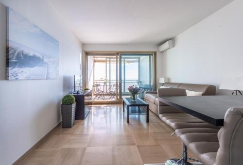 un salon avec un canapé et une table dans l'établissement SEA FRONT - panoramic sea view studio with terrace, à Nice