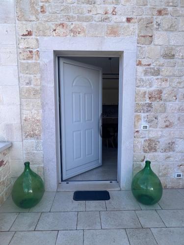 two green vases sitting in front of a door at Trulli in Vigna in Selva di Fasano