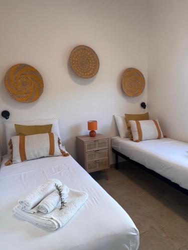 a room with two beds and a nightstand and two beds sidx sidx at Trulli in Vigna in Selva di Fasano