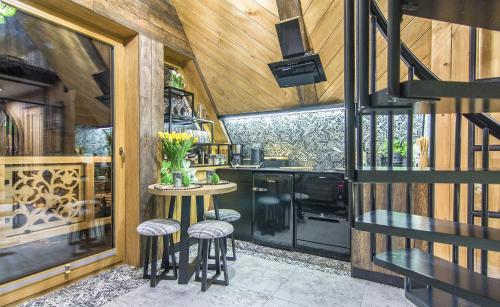 a kitchen with a table and stools in a house at Brzozowa Osada - Premium Chalets Zakopane in Zakopane