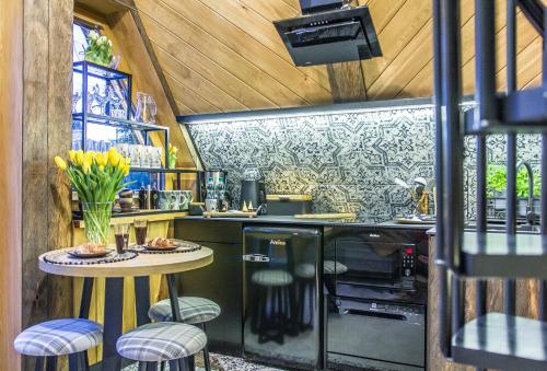 a kitchen with a table and chairs in a room at Brzozowa Osada - Premium Chalets Zakopane in Zakopane