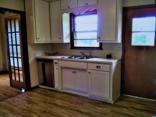 eine leere Küche mit einem Waschbecken und einem Fenster in der Unterkunft s1. Beautiful home in Historic Scottsboro in Scottsboro