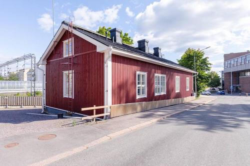 a red building sitting on the side of a street at Unique & premium apartment with free wifi & parking for 2 cars in the center of Kerava in Kerava