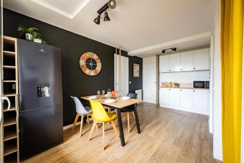 une cuisine et une salle à manger avec une table et des chaises jaunes dans l'établissement Life&Travel - Appart cosy - 4 chambres - Bordeaux, à Bordeaux