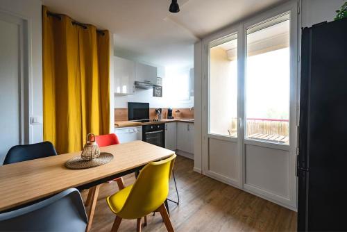 une cuisine avec une table en bois et des chaises jaunes dans l'établissement Life&Travel - Appart cosy - 4 chambres - Bordeaux, à Bordeaux