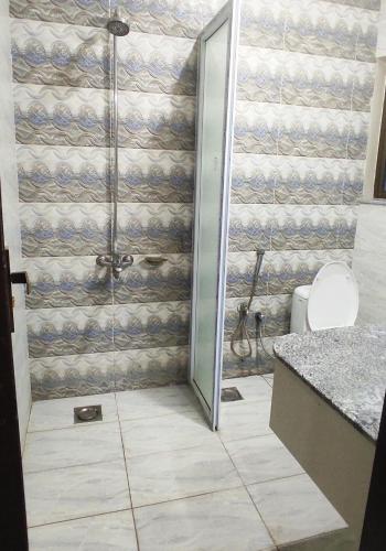 a shower with a glass door in a bathroom at Hotel Daffodils in Rawalpindi