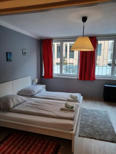ブダペストにあるBenkoapartmentsのベッドルーム1室(赤いカーテン付きの大型ベッド1台付)