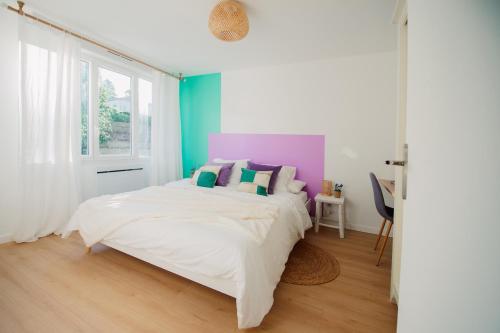 1 dormitorio con 1 cama grande y almohadas coloridas en Casita - Comme une petite maison - Parking gratuit, en Valence