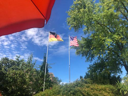 two flags flying in the sky next to trees at Haus am Kurpark in Schömberg