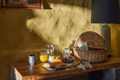 - une table avec des aliments pour le petit-déjeuner et un panier d'oranges dans l'établissement Mesón Hidalgo, à San Miguel de Allende
