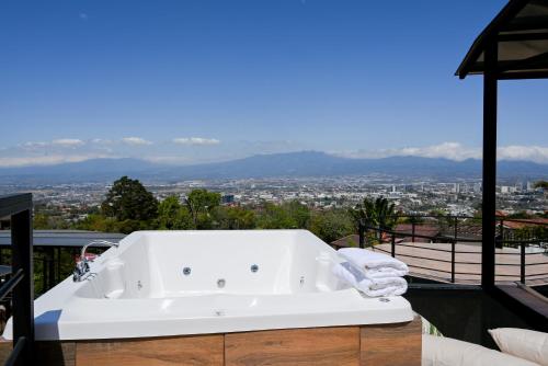 a white bath tub sitting on top of a balcony at Alma Glamping in Escazu