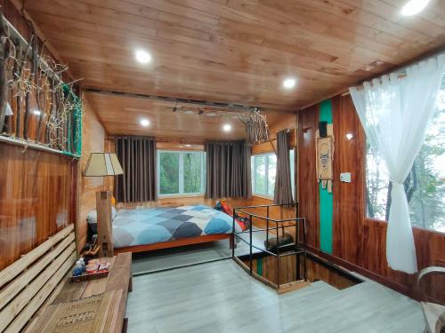 um quarto com uma cama e paredes de madeira em Gió bungalow em Sapa
