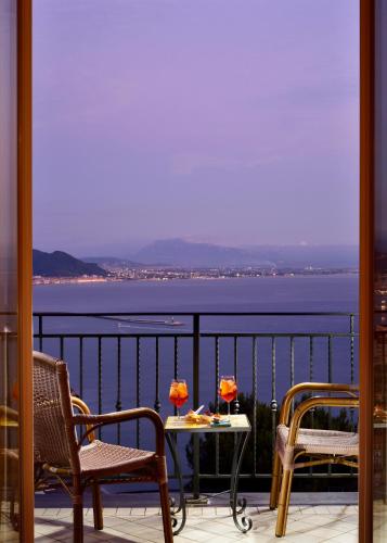 a table and chairs on a balcony with a view of the water at Hotel Raito Wellness & SPA in Vietri sul Mare