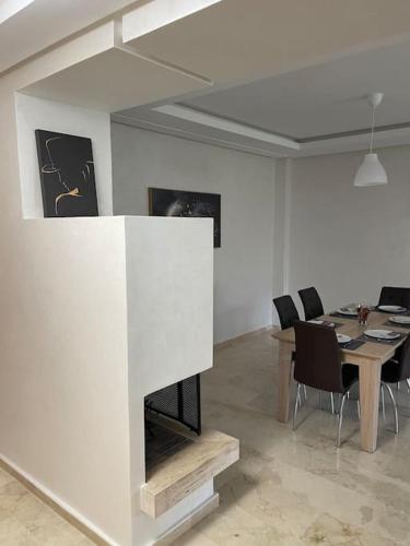 a living room with a fireplace and a table with chairs at Chic & cosy Flat Near Airport lockbox fast wifi in Nouaceur