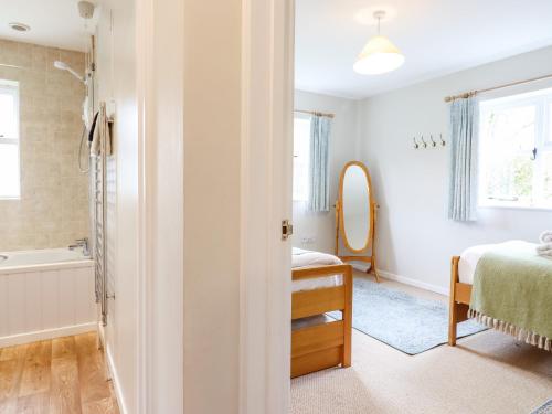 um quarto com uma cama e uma casa de banho com uma banheira em The Brambles em Colchester