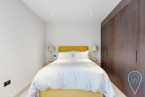 um quarto com uma cama grande e uma cabeceira amarela em Modern 1BR home in Islington! em Londres