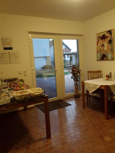 ein Esszimmer mit einem Tisch, einem Tisch und einem Fenster in der Unterkunft Gästehaus Samira in Purbach am Neusiedlersee