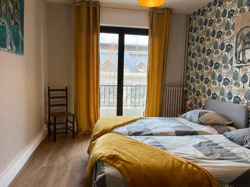 - une chambre avec un lit et une fenêtre avec des rideaux jaunes dans l'établissement Appartement d’artiste lumineux central 76m2, à Perpignan