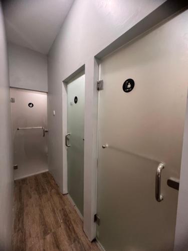 a hallway with two elevators in a room with wood floors at Sleep Studio Hotel City Center Surabaya in Tembok