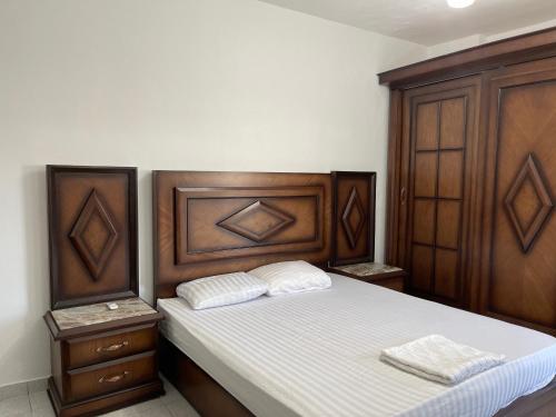 een slaapkamer met een houten bed met 2 witte kussens bij Apartment in the City Center Neama Bay and free Wi-Fi in Sharm El Sheikh