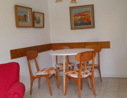 una mesa con 4 sillas y una mesa con pinturas en la pared en Tu Apart en Bariloche 22 en San Carlos de Bariloche