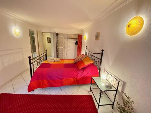 une chambre avec un lit avec une couette rouge dans l'établissement Centre of Olonzac, 2 bedrooms & private sunny rooftop terrace, à Olonzac