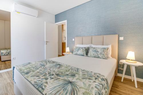 1 dormitorio con 1 cama grande y pared azul en Rua da Praia, en Póvoa de Varzim