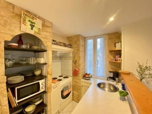 une petite cuisine avec un évier et une cuisinière dans l'établissement Centre of Olonzac, 2 bedrooms & private sunny rooftop terrace, à Olonzac