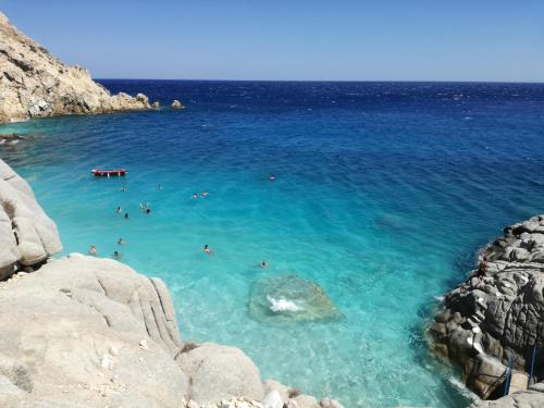 a group of people swimming in the blue ocean at Christos Raches traditional houses in Raches