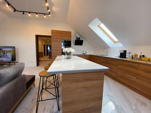 cocina con encimera blanca y sala de estar en Strzyzewo Witkowskie Luxury Apartment 