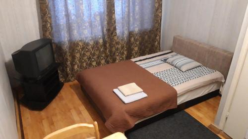 Habitación pequeña con cama y TV. en TORE KÜLALISTEMAJA en Tallin