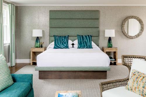 um quarto com uma cama grande e almofadas azuis e brancas em The Sydney, The Edgartown Collection em Edgartown