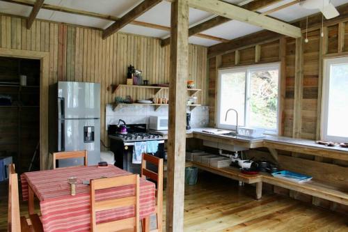 a kitchen with a table and a refrigerator at The Birds Nest in Bocas del Toro
