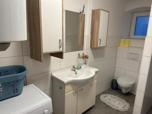 Baño blanco con lavabo y aseo en Ferienwohnung Niederthalheim, 