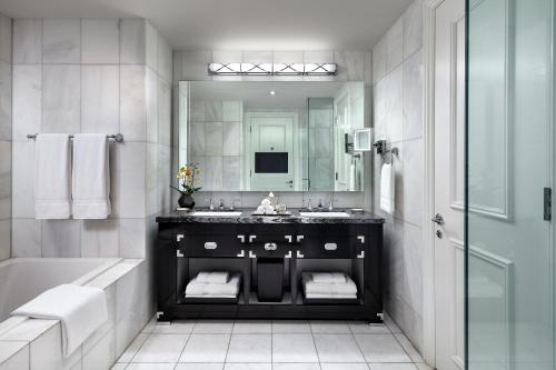 a bathroom with a sink and a tub and a mirror at The St. Regis Toronto in Toronto