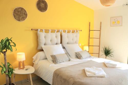 um quarto com uma grande cama branca com paredes amarelas em Bar des Amis em Villars