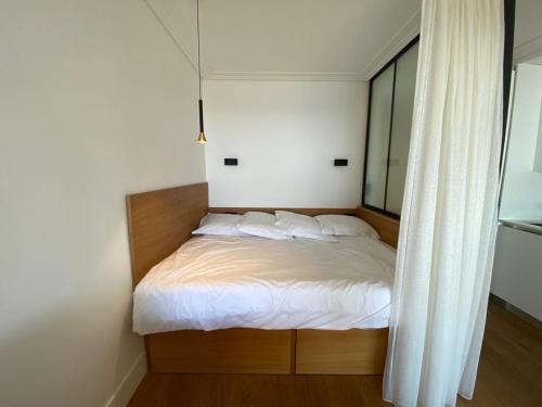 ein Bett mit weißer Bettwäsche und Kissen in einem Schlafzimmer in der Unterkunft CENTER BAY in Juan-les-Pins