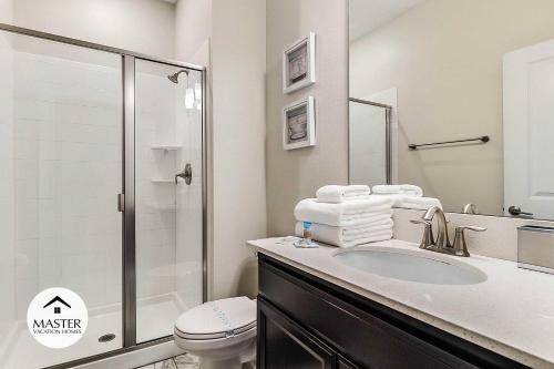 uma casa de banho com um lavatório, um WC e um chuveiro em 4 Bedrooms 3 Bathrooms Storey Lake 4925 Wa em Kissimmee
