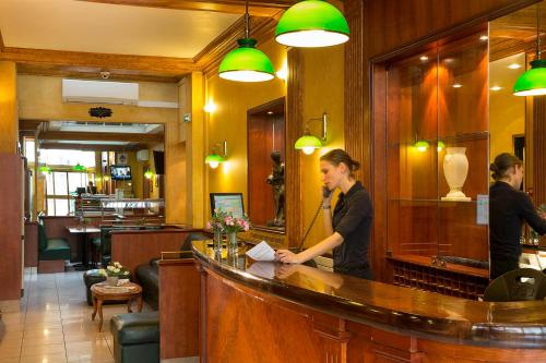 a man standing at a bar in a restaurant at Hotel Terminus Lyon in Paris