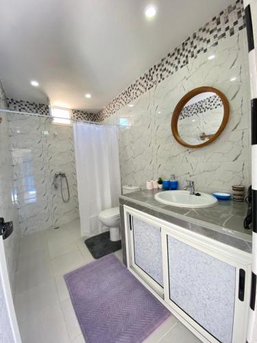 a bathroom with a sink and a toilet and a mirror at Latifa house in Oualidia