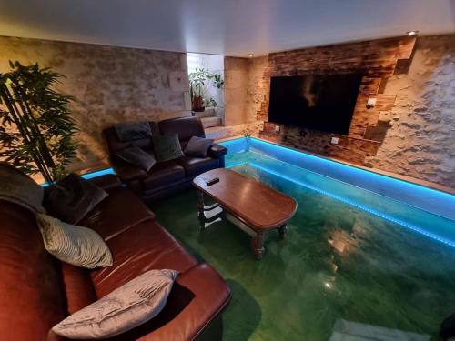 a living room with a pool in the middle of the room at la villageoise in Leignes-sur-Fontaine