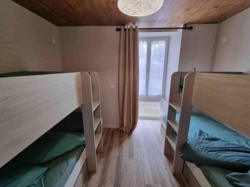 a room with two bunk beds and a window at la villageoise in Leignes-sur-Fontaine