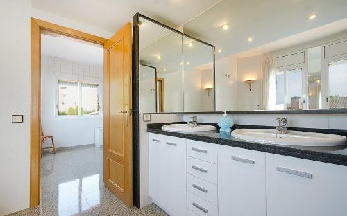 een badkamer met 2 wastafels en een grote spiegel bij R11 Casa Blanca con gran jardin y piscina in Calafell