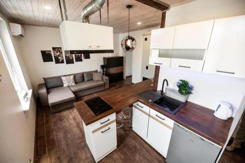 uma cozinha com armários brancos e uma sala de estar em Chill Inn with sauna em Pärnu