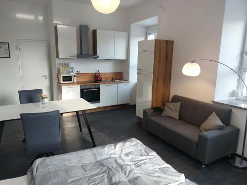 uma sala de estar com um sofá, uma mesa e uma cozinha em Apartments im Mardefeldpalais em Ansbach