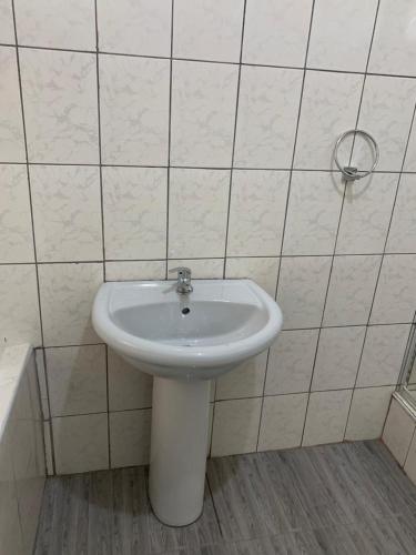 a bathroom with a white sink and a tub at Tanzanite Guesthouse in Dannhauser