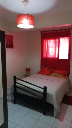 um quarto com uma cama grande e uma cabeceira vermelha em Charmant petit T2 dans maison em Vieux Bourg