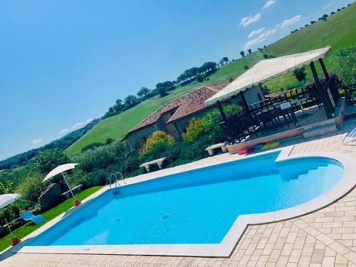 una gran piscina azul frente a una casa en 8380 Agriturismo L'Oleandro, en Montemerano